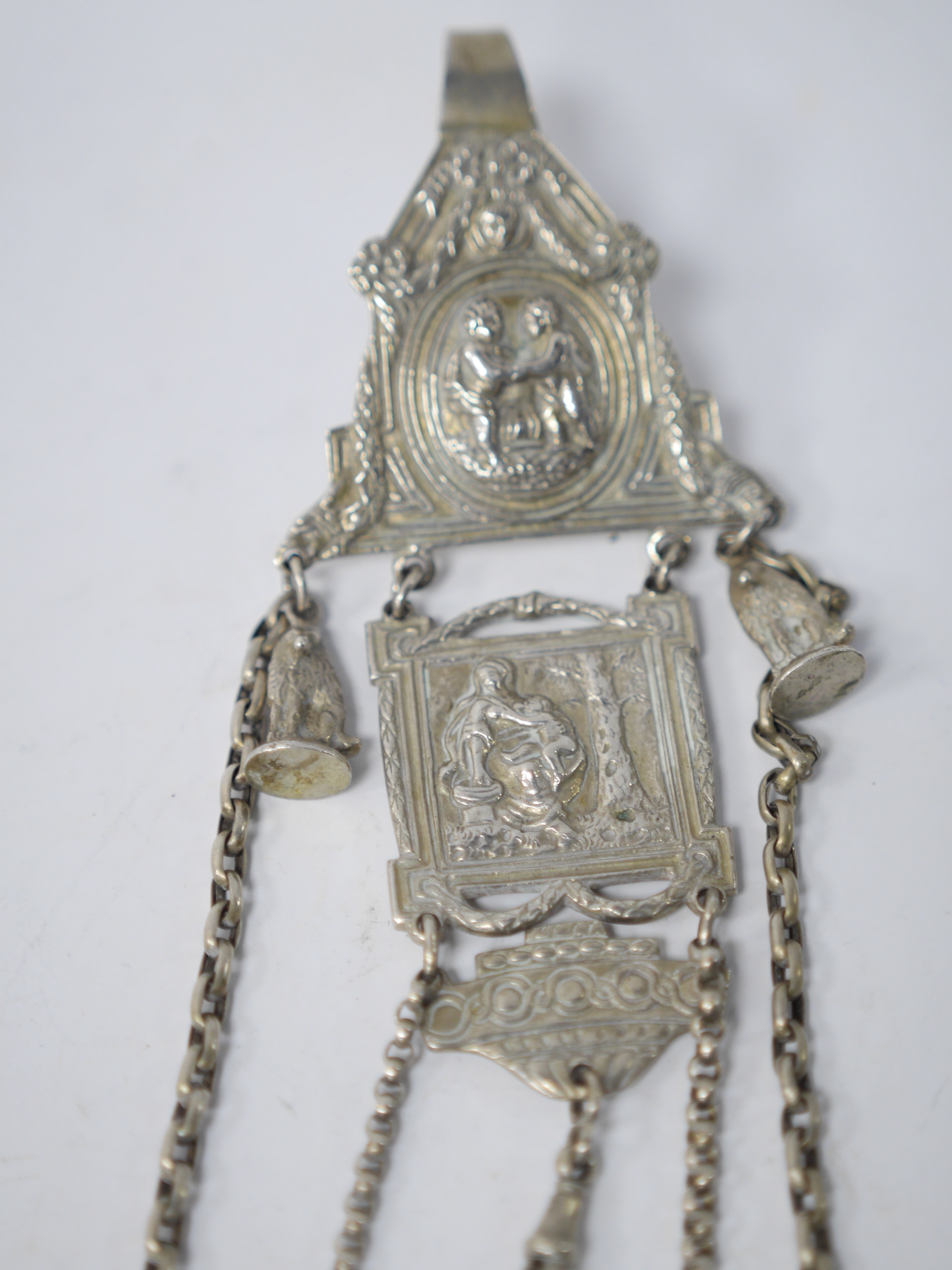 A late 19th/early 20th century continental white metal chatelaine, hung with six assorted accoutrements including a small silver box, a George III silver oval snuff box, a pen knife, compass and cross pendant. overall ap